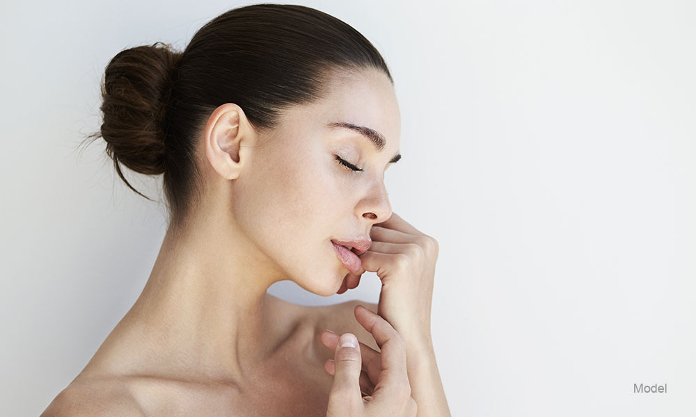 woman smiling touching her face