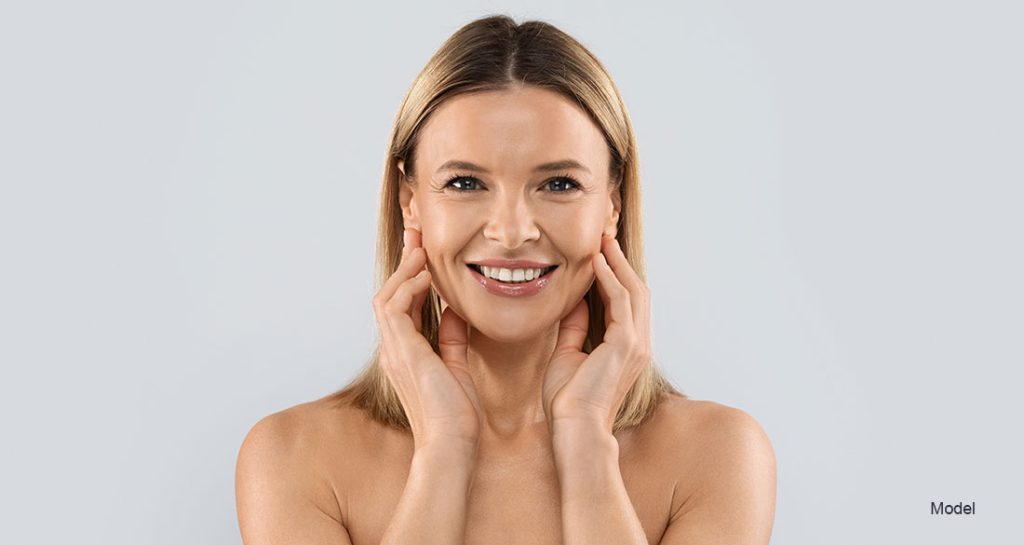 mature woman smiling touching her face